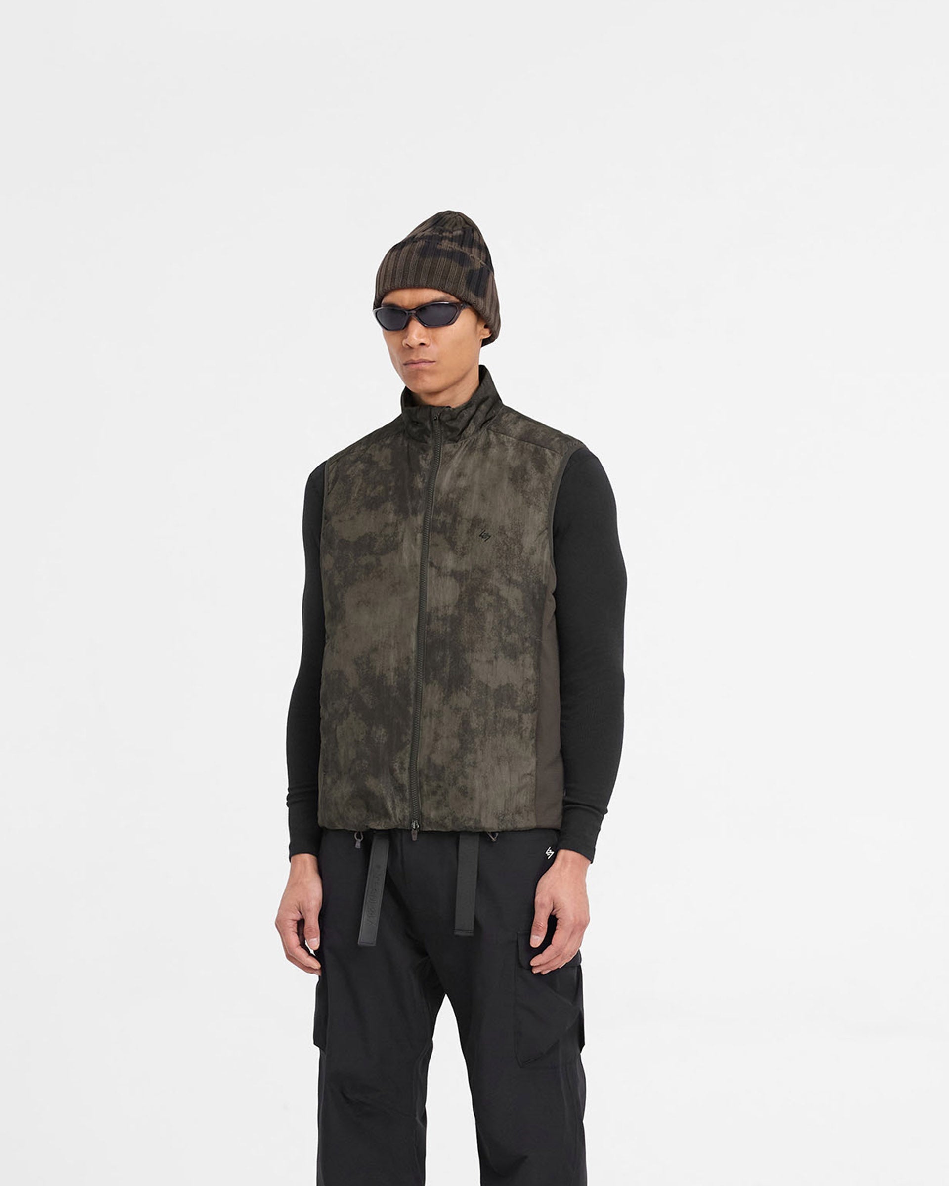 Man wearing a terrain printed gilet on a plain white background | Team 247 Insulated Gilet in Terrain | Insulated gilet with micro ripstop fabric and DWR coating | 247 Outerwear | Represent Clo