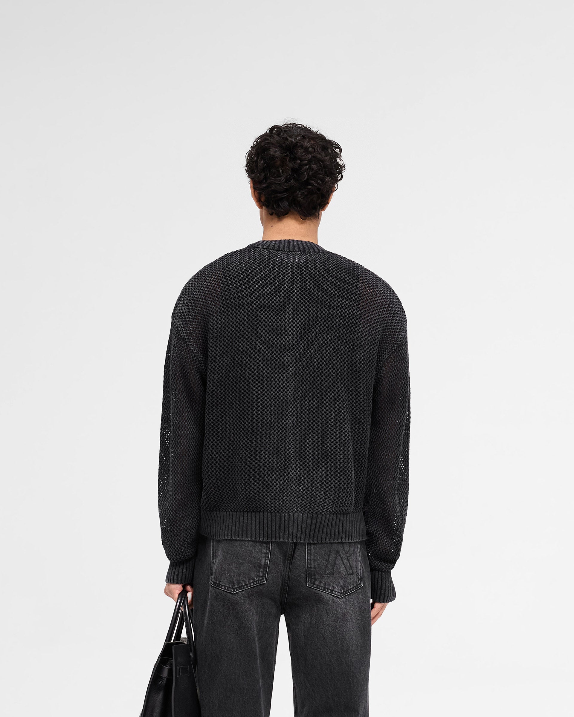 Man wearing a black sweater on a plain white background | Open Gauge Knit Sweater in Jet Black | Oversized knitwear with ribbed trim | SS25 Knitwear | Represent Clo