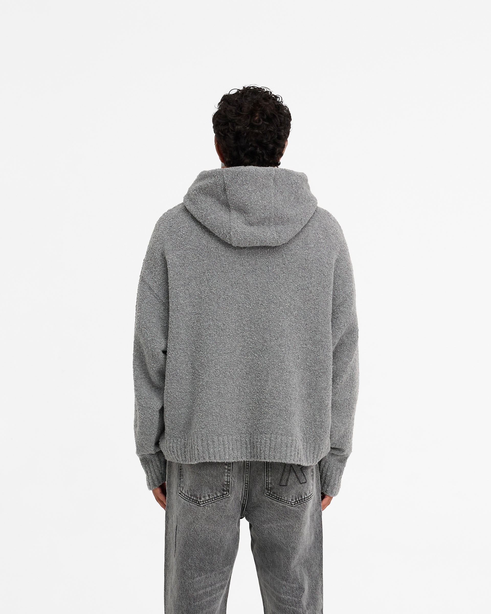 Man wearing an oversized grey hoodie on a plain white background | Heavy Boucle Hoodie in Rock | Oversized boucle knit hoodie with ribbed details | FW24 Knitwear | Represent Clo
