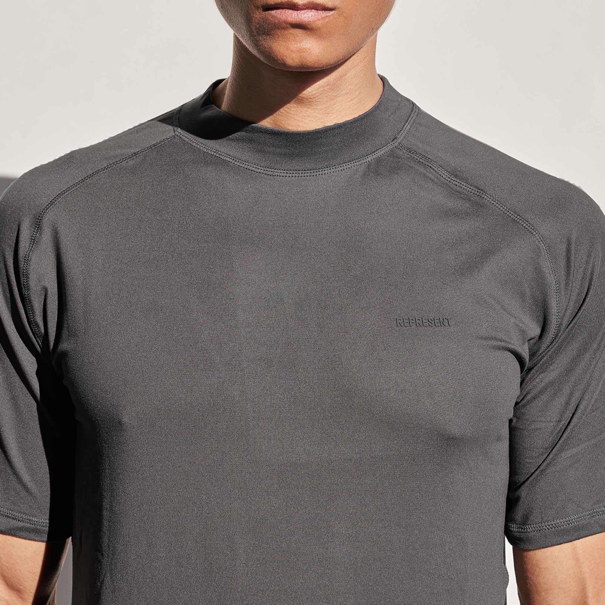Back product image of a mens grey t-shirt on a plain white background | 247 T-Shirt in Grey | Slim fit t-shirt with raglan sleeves and rubber logo branding | 247 T-Shirts | Represent Clo